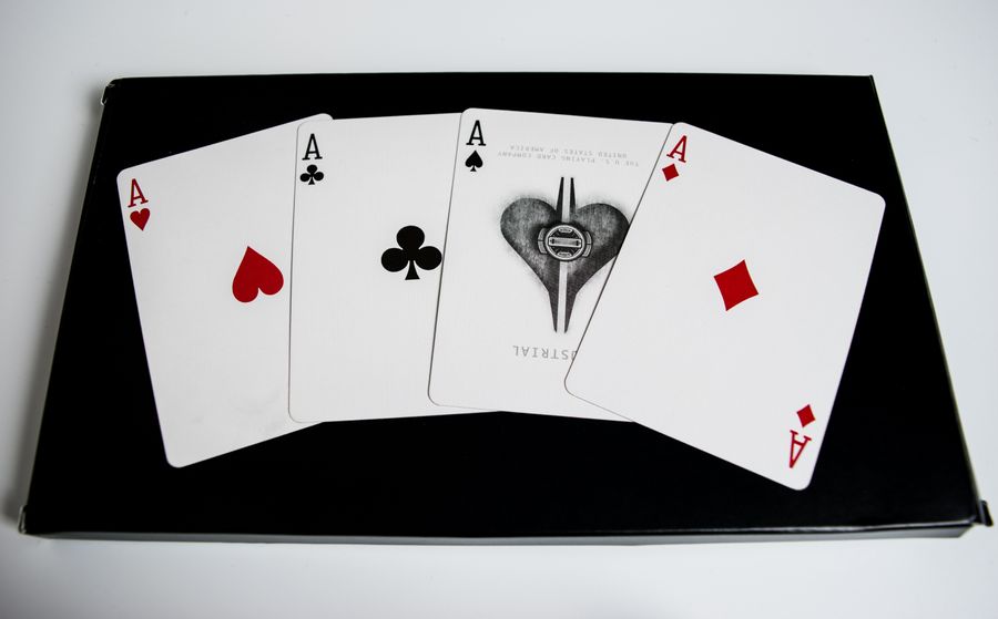 Empat kartu as dan keping poker di atas meja